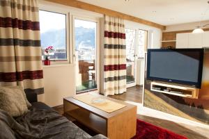 a living room with a flat screen tv and a couch at Apart Sailer in Ried im Oberinntal