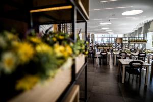 a dining room with tables and chairs and flowers at Hotel Cap Negret in Altea