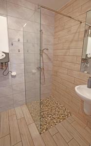 um chuveiro com uma porta de vidro na casa de banho em Apartamenty NK em Mielno