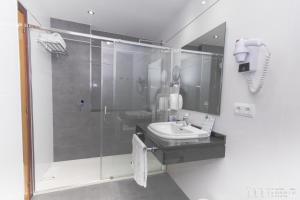 La salle de bains est pourvue d'une douche et d'un lavabo. dans l'établissement Hotel Spa Nanin Playa, à Sanxenxo