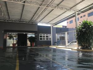 an empty parking lot in front of a building at Hotel Manzoni in Campo Grande