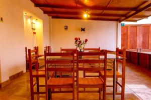 a dining room with a table and chairs and flowers at Mangata in Lobitos