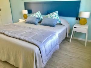 a bedroom with a large bed with blue walls at Il Miraggio in Fregene