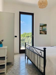 Un dormitorio con una cama y una ventana grande. en Villa A'mare, en Savelletri di Fasano