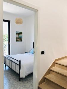 Un dormitorio blanco con una cama y una escalera. en Villa A'mare, en Savelletri di Fasano
