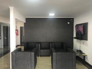 a living room with a couch and a black wall at Hotel Manzoni in Campo Grande