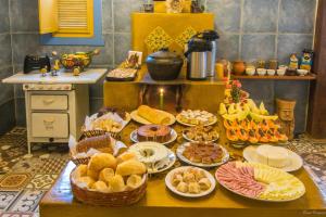 una mesa con muchos platos de comida. en Arraial Velho Pousada Tematica, en Tiradentes