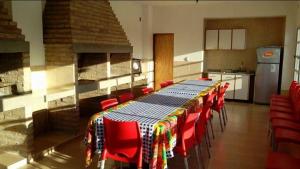 a kitchen with a table with red chairs and a fireplace at APART SUR II in Termas de Río Hondo