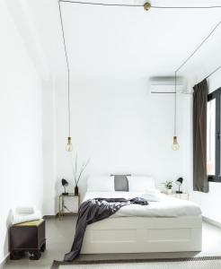 a bedroom with white walls and a large white bed at Concierge Monastiraki in Athens