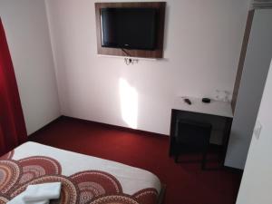 a small room with a bed and a tv on the wall at Motel Dreams in Novi Travnik