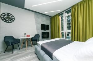 1 dormitorio con 1 cama y 1 mesa con sillas en Luxury Apartments, en Kiev