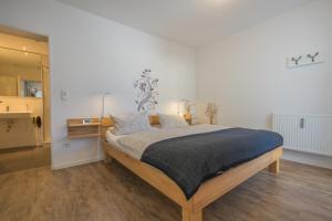 ein Schlafzimmer mit einem Bett in einem weißen Zimmer in der Unterkunft Ferienwohnungen Alpentraum - Wiesenblume in Oberstdorf