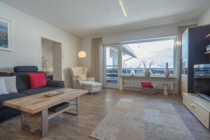 ein Wohnzimmer mit einem Sofa und einem Tisch in der Unterkunft Ferienwohnungen Alpentraum - Wiesenblume in Oberstdorf