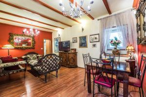 a living room with red walls and a table and chairs at Emperor's Suites in Split