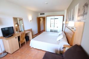 Habitación de hotel con cama y TV en Ohtels Vil·la Romana, en Salou