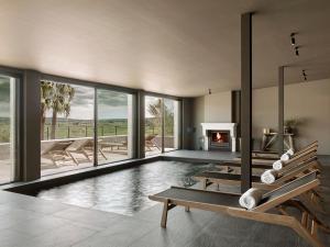 a swimming pool with a fireplace in a house at Finca Serena Mallorca, Small Luxury Hotels in Montuiri