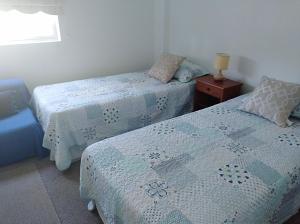 a bedroom with two beds and a table with a lamp at Algarrobo Bosques de la Candelaria in Algarrobo +28 photos