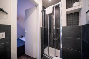 a bathroom with a shower with a glass door at B City Hotel in Bardolino
