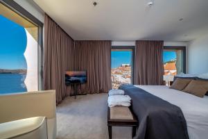una camera con un grande letto e una TV di Bellevue Superior City Hotel a Šibenik