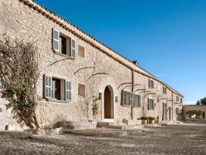 an old stone building with windows and a street at Finca Serena Mallorca, Small Luxury Hotels in Montuiri
