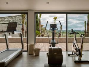 a gym with cardio machines and a large window at Finca Serena Mallorca, Small Luxury Hotels in Montuiri