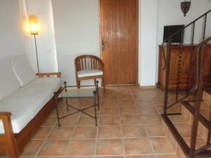 サンタ・エウラリア・デス・リウにあるAgroturismo Xarcのベッド1台、椅子、階段が備わる客室です。