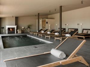 a swimming pool with chairs and a fireplace at Finca Serena Mallorca, Small Luxury Hotels in Montuiri