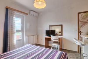 a bedroom with a bed and a desk and a mirror at Vila Milla in Premantura