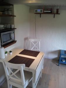 a table and chairs in a room with a tv at Lilleledgaard Apartment in Ringkøbing