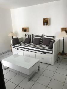 a white couch with black and white pillows in a living room at STUDIO TOUT A PIEDS in Sanary-sur-Mer