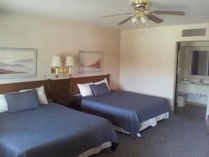 a hotel room with two beds and a ceiling fan at El Rancho Boulder Motel in Boulder City