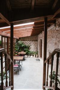 eine Terrasse mit Tischen und Stühlen und einer Steinmauer in der Unterkunft Kentrikon in Ioannina