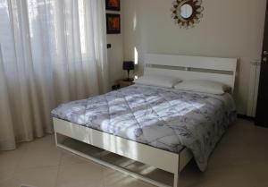 um quarto com uma cama branca e almofadas brancas em A Casa di Marcy em Reggio di Calabria