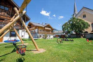 einen Spielplatz in einem Hof neben einem Gebäude in der Unterkunft Feriengut Ottacherhof in Hollersbach im Pinzgau