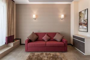 ein Wohnzimmer mit einer roten Couch in einem Zimmer in der Unterkunft New Splendid Hotel & Spa - Adults Only (+16) in Mamaia