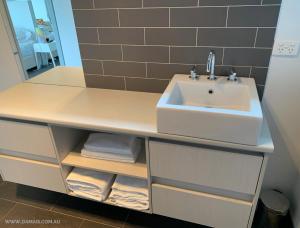a bathroom vanity with a sink and a mirror at Damais - 4 king or 8 single beds WiFi, Netflix, Alexa, pet friendly in Daylesford