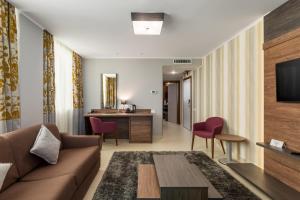 een woonkamer met een bank en een tafel bij Splendid Conference & Spa Hotel – Adults Only in Mamaia