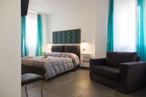 een slaapkamer met een bed en een stoel bij My Way - Suite - Rooms - Palazzo San Matteo in Palermo