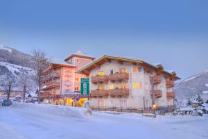 a building on a snow covered street in front at Hotel Steiger in Neukirchen am Großvenediger