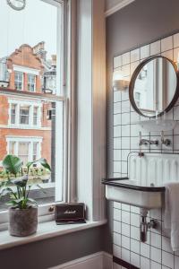 uma casa de banho com um lavatório e uma janela em The Pilgrm em Londres