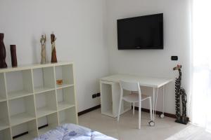 a room with a desk and a tv on a wall at A Casa di Marcy in Reggio di Calabria