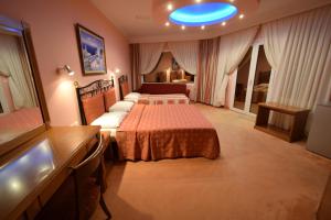 a hotel room with two beds and a blue ceiling at Hotel Aperio in Paralia Katerinis