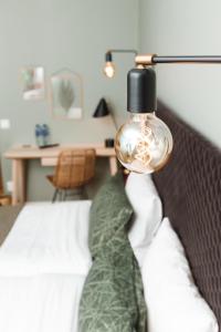 een slaapkamer met een bed met een lamp erop bij Hotell Lassalyckan in Ulricehamn