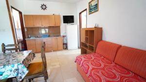 a living room with a couch and a kitchen at Apartments Roberta in Kožino
