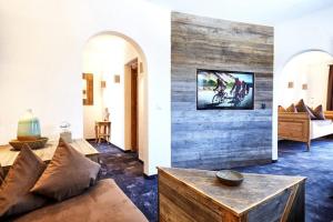 ein Wohnzimmer mit einem Sofa und einem TV an der Wand in der Unterkunft Hotel Gasthof Eder GmbH in Gmund am Tegernsee