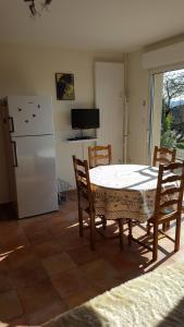 a kitchen with a table and chairs and a refrigerator at Gite Chez Monique in Baubigny