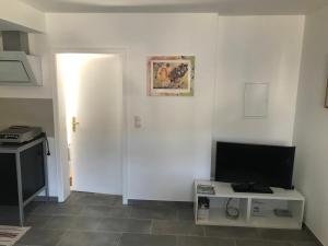 ein Wohnzimmer mit einem TV und einer weißen Wand in der Unterkunft Im Mückenberg 4 in Lahnstein