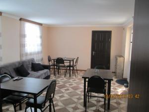 a living room with a couch and tables and chairs at Guesthouse Elli & Cottages in Kazbegi