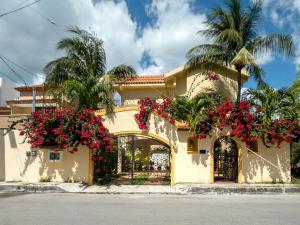 a yellow building with pink flowers on it at Casa Zarah in Puerto Morelos