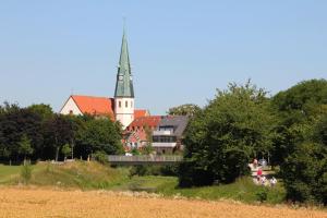 una iglesia con un campanario en medio de una ciudad en Hotel Geschermann, en Sendenhorst